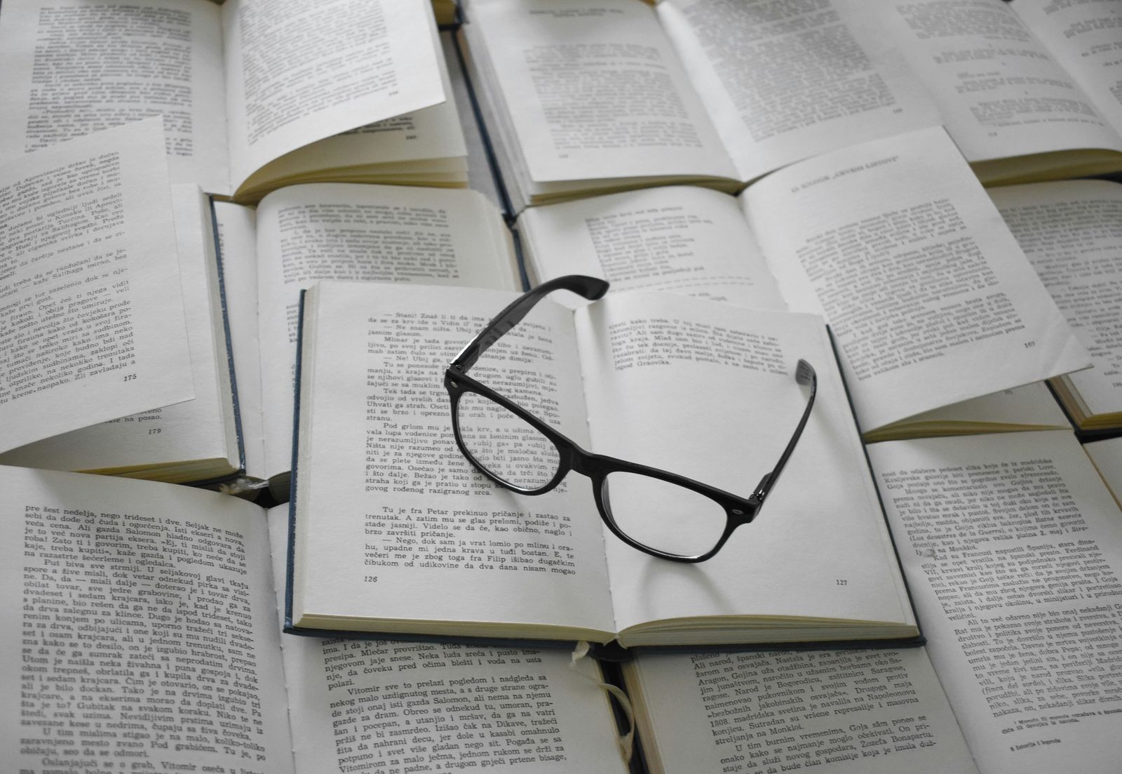 Libri aperti e occhiali da lettura
